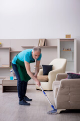 Old male contractor cleaning the house