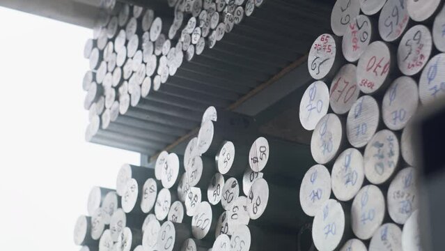 Experienced craftsman takes out metal bar from rack. Various steel workpieces lies on shelves. Factory warehouse with production materials. Manufacturing, industrial and technology Generative AI