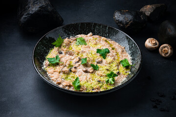Italian kitchen risotto with parmesan, champignon and greens.