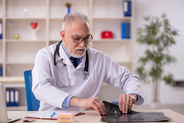 Old male doctor radiologist working in the clinic