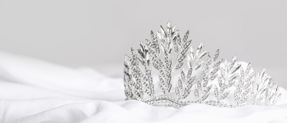 Beautiful tiara on white prom dress against grey background, closeup © Pixel-Shot
