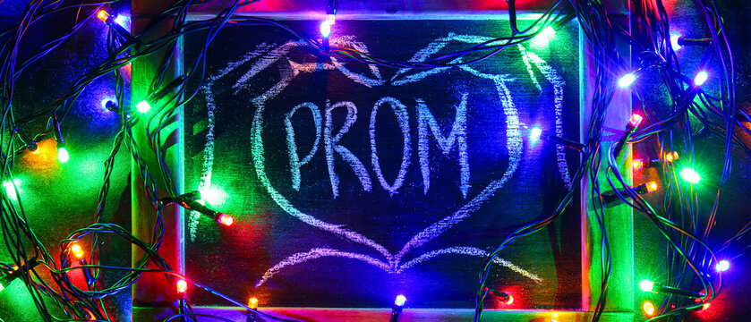 Chalkboard with word PROM and glowing colorful lights on dark background - Powered by Adobe