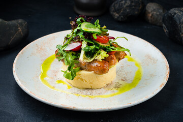 Sausages with mashed potatoes and fresh salad of cucumber, radish, tomato, lettuce and arugula.
