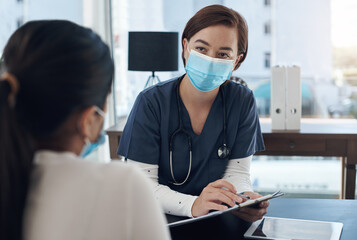 Are these details correct. a young female doctor writing down a patients information in an office.