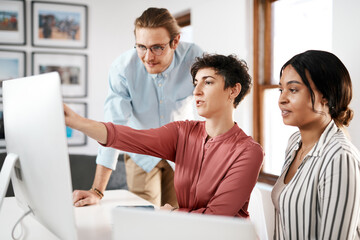 Lets move this around. a diverse group of businesspeople working on a computer together during a meeting in the office.
