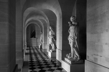 Marble statues in the historical hallway Ground Gallery of Versailles Palace, near Paris, France....