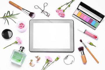Fototapeta na wymiar Composition with modern tablet computer, cosmetics, accessories and carnation flowers on white background