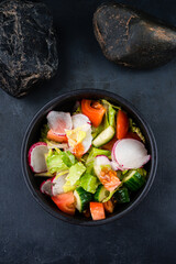 Green salad with cucumbers, lettuce, cherry tomatoes, and radish.