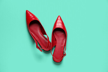 Pair of stylish red shoes on color background