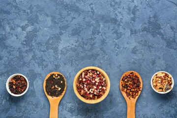 Composition with different types of dried fruit tea on blue grunge background