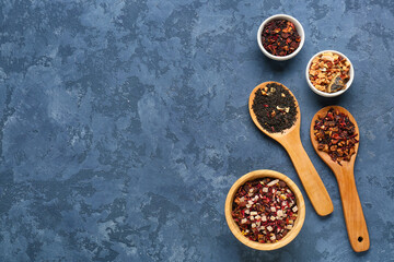 Composition with different types of dried fruit tea on blue grunge background
