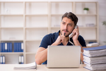 Young male employee sitting at workplace