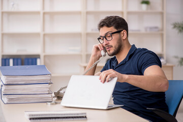 Young male employee sitting at workplace