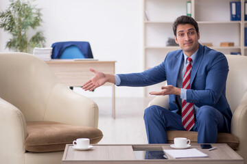 Young male employee sitting in the office