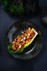 Dinner beef goulash with beans, cucumbers, onions and croutons in a lettuce leaf.