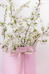 tree branches with blooming spring flowers in a pink gift box