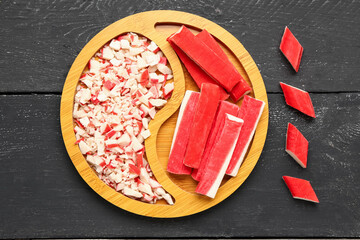 Plate with tasty crab sticks on dark wooden background © Pixel-Shot