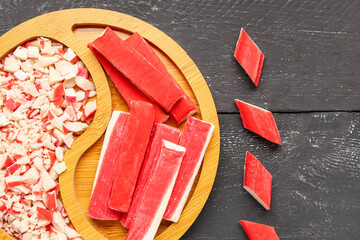 Plate with tasty crab sticks on dark wooden background, closeup © Pixel-Shot