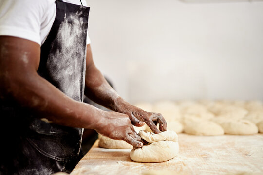 After rolling these up Ill let then sit for a few minutes. a male baker busy shaping dough at work.