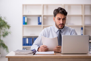 Obraz premium Young male employee working in the office