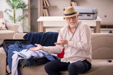 Old man preparing for trip at home