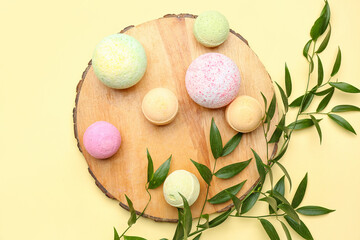 Wooden stand with bath bombs and plant branches on beige background