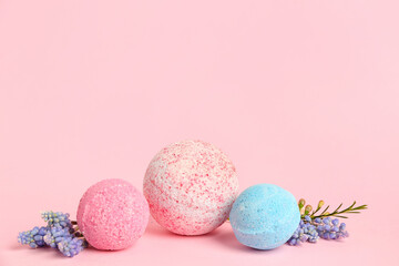 Bath bombs with flowers on pink background