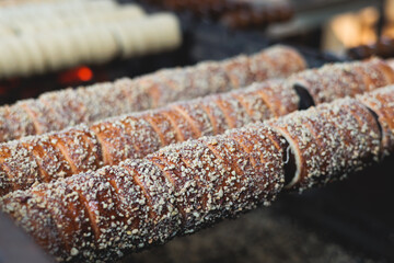 Trdelnik, traditional czech and european sweet street food, process of baking and cooking on street...
