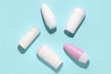 Different deodorant bottles on blue background