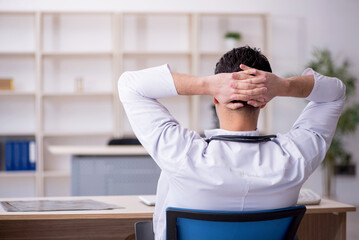 Young male doctor sitting in the clinic