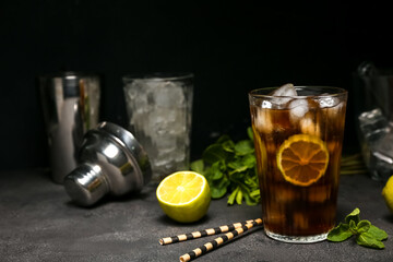 Glass of cold Cuba Libre cocktail on dark background