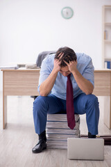 Young male employee unhappy with excessive work in the office