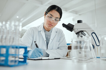 Proving my hypothesis correct. a young woman making notes in her lab.