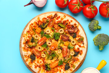 Vegetable pizza with ingredients on blue background