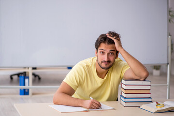 Young male student preparing for exams in the classroom