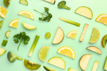 Composition with different fresh green vegetables and fruits on pale green background