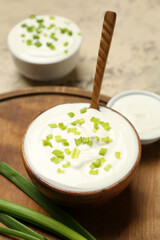 Composition with sour cream and green onion on grunge table