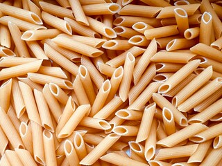 Full frame of uncooked penne pasta noodles