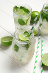 Mason jar of tasty mojito on light wooden background