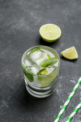 Glass of tasty mojito on dark background