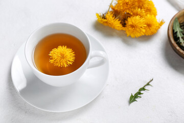 Cup of healthy dandelion tea on white background