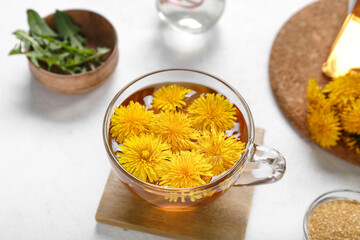 Glass cup of healthy dandelion tea on white background