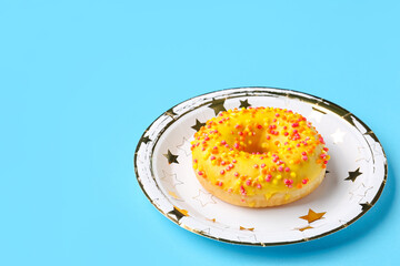 Paper disposable plate with doughnut on blue background