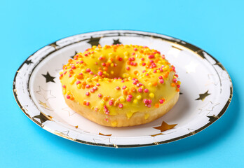 Paper disposable plate with doughnut on blue background
