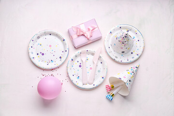 Paper disposable plates with gift, party hats and balloon on white background