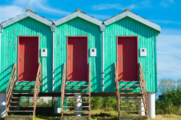 Fototapeta na wymiar fisherman little and colourful huts in a row, green emerald with red door in escaroupim, portugal
