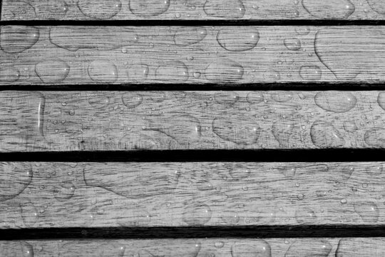 neutral background, paralell wood planks with water ponds after rain, quietness in grey
