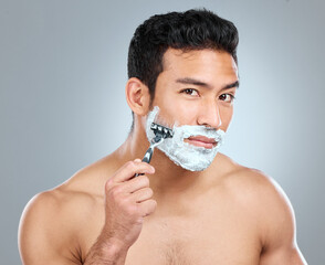 Be gentle and let your razor do the work. Studio shot of a man shaving with a disposable razor.