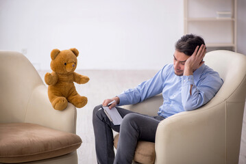 Young male psychologist meeting with toy bear