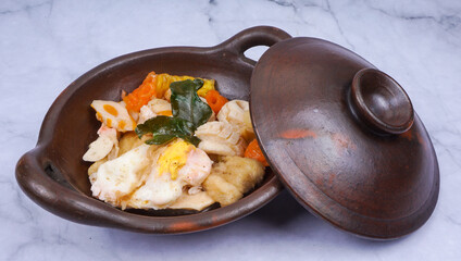 Indonesian street food cuisine, seblak in traditional wok pan, over marble table